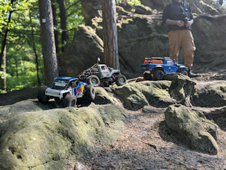 Three RC crawlers on rocky ground